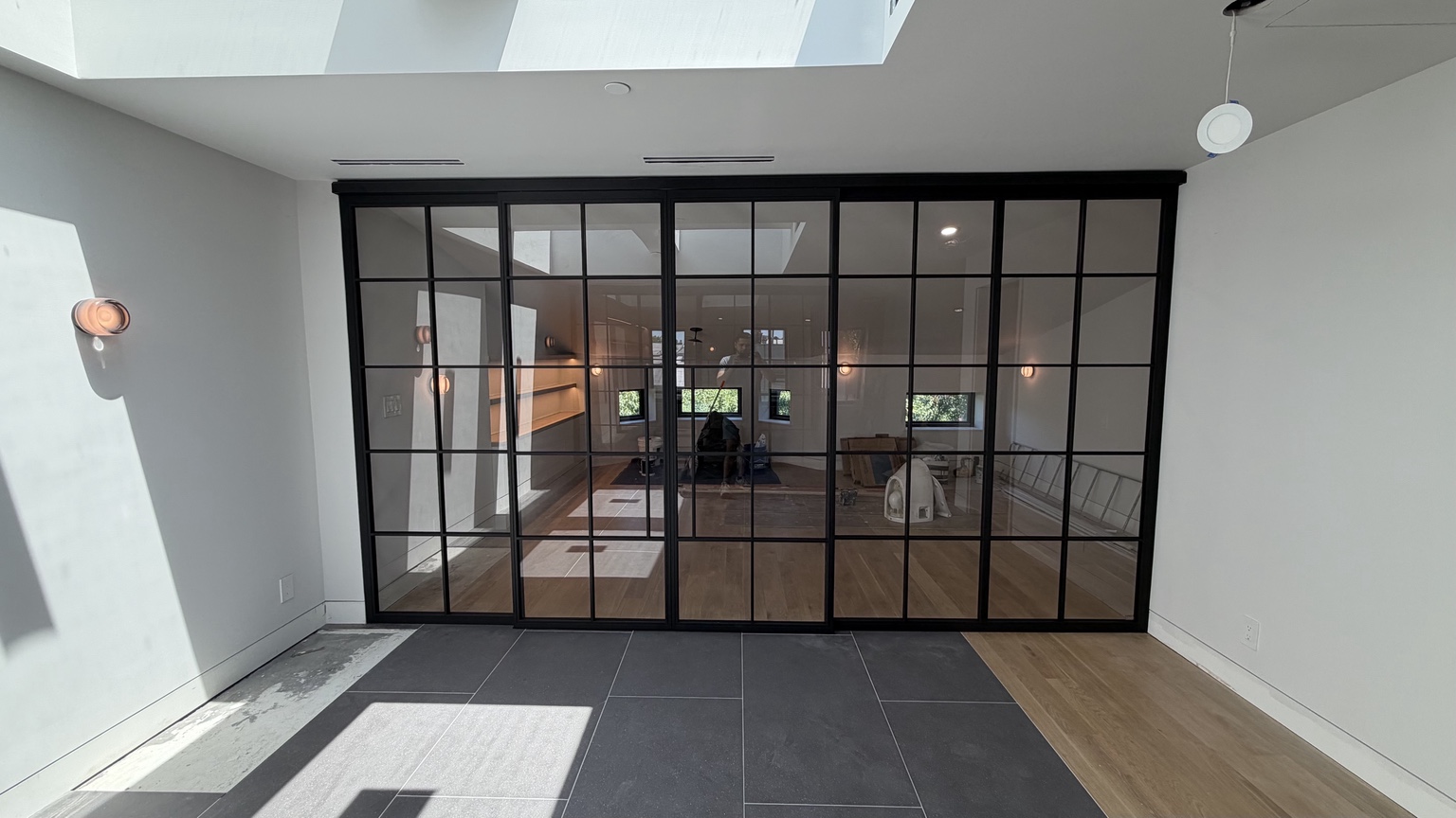 Wide black framed glass room enclosure with sliding panels