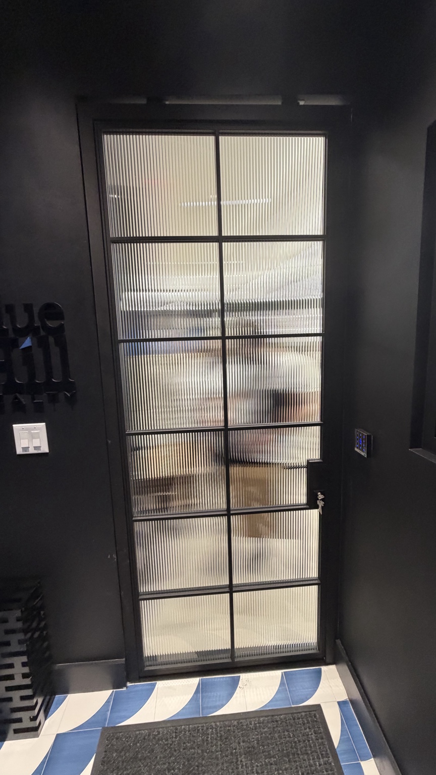 Black framed door with fluted privacy glass